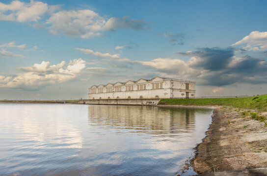 Rybinsk, yaroslavl region, russia - august 6, 2026: Historic stalinesque architecture building of rybinsk hydroelectric power station or ges with reflection in water reservoir.