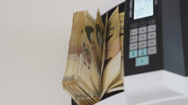 Close-up Fixed Shot of Money Counting Machine Counting 100 Crisp 50,000 Won Banknotes (Cash, Banking, Finance)