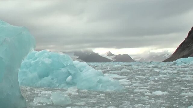 Witness an extreme journey across the vast Arctic Ocean, where countless frozen blue ice fragments drift alongside ancient glaciers.