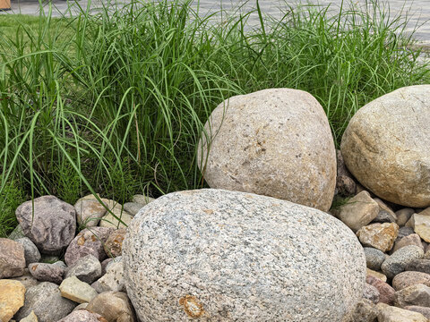 Large granite boulders with ornamental grass in modern landscape design