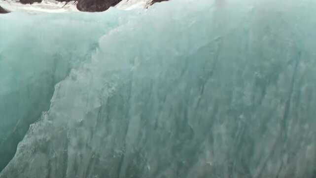 An awe-inspiring voyage through the Arctic Ocean reveals a colossal glacier. Its towering blue ice wall dominates, surrounded by a serene expanse of floating ice. A truly extreme travel journey.