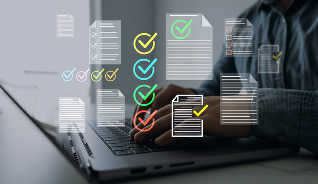 Business person checking digital documents on laptop with checklist approval icon, verification, workflow control, productivity and online document management.	

