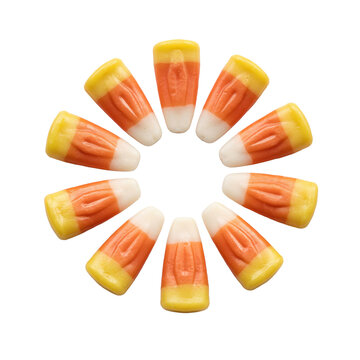 Ten pieces of tri-colored candy corn arranged in a circular pattern on a white surface isolated on a transparent background