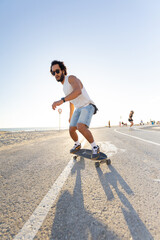 Skateboarding on a sunny day at the beach promenade with people in the background © KONSTANTIN SHISHKIN