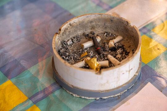 
an ashtray containing cigarette butts and ash