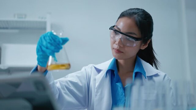 Research medical or cosmetic,science biotechnology concept.Asian female research scientist preparing and analyzing microscope slides in research lab.