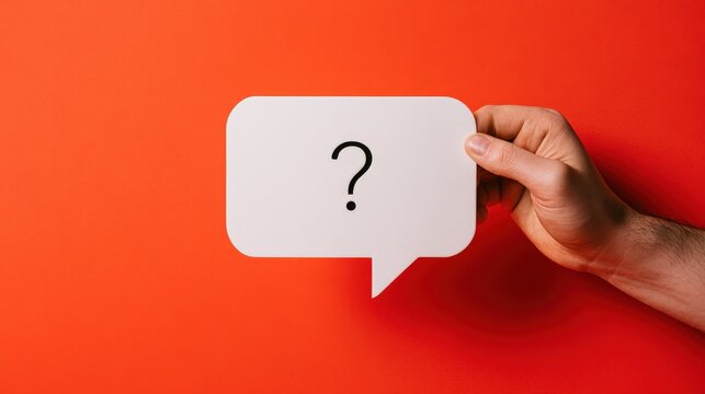 A hand holds a speech bubble with a question mark on a vibrant red background. Perfect for business uncertainty and problem solving concepts.