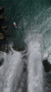 Amazing aerial view of adventure scenery of people paddling under waterfall