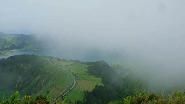 Locked-off viewpoint of Sete Cidades caldera as cloud drifts across the crater rim  atmospheric Azores opener