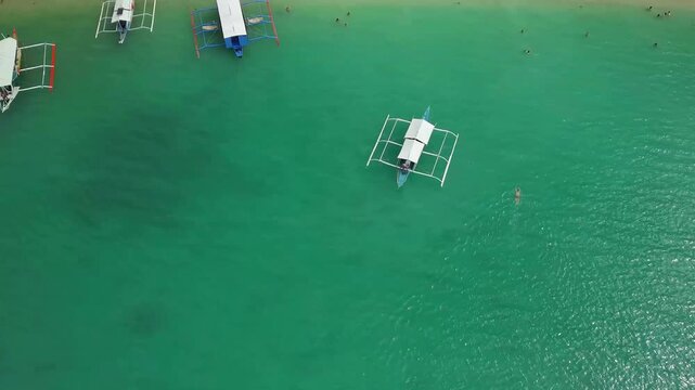 Aerial drone footage of White Beach in Port Barton, San Vicente, Palawan, Philippines. The video shows the long white sand beach, dense coconut palm forest and turquoise tropical waters 