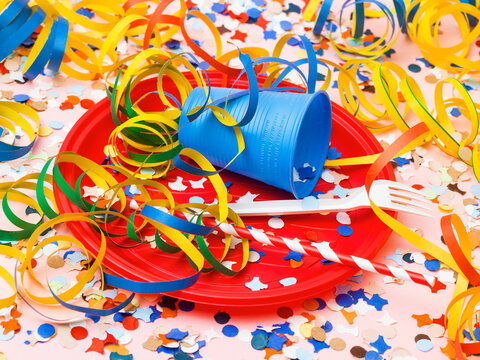 Overturned Blue Cup Stuffed with Streamers on Red Party Plate