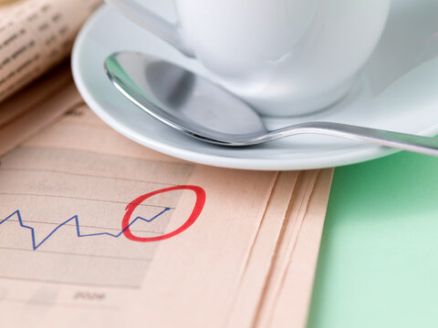 Macro Coffee Cup and Spoon on Circled Financial Chart