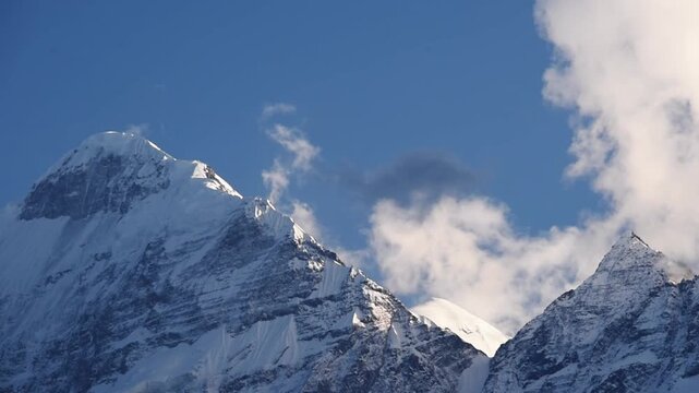 Snow-capped peaks of the Nilgiri ridge with drifting cloud against blue sky, Upper Mustang, Nepal