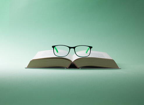 Minimalist Composition of Eyeglasses on Open Book
