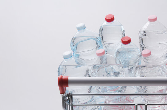 Plastic Water Bottles Loaded in Supermarket Shopping Cart with Copy Space