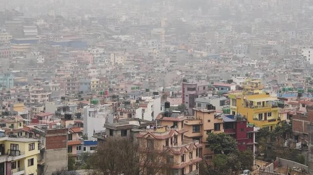 Smog over dense Kathmandu cityscape with a bird in flight, hazy valley rooftops