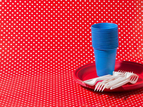 Kids Birthday Party Plastic Supplies on Red Polka Dot Background