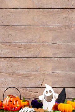 Trick or treat Halloween holiday outdoor party background. Various Halloween accessories, ghost decoration, basket with candies, colorful pumpkins, autumn fall leaves on green grass lawn background