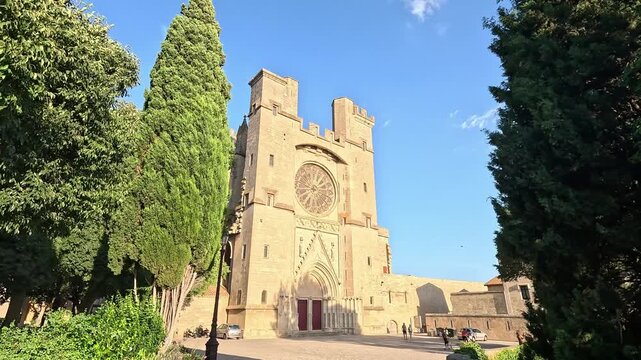 Approching West facade and towers of the fortified Cathedrale Saint-Nazaire, Beziers, Herault, Occitanie, France