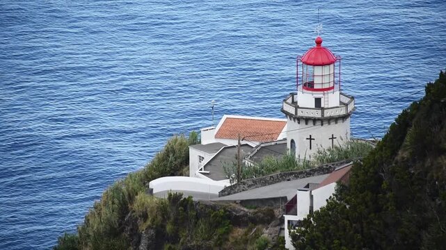 close up Red dome and cruciform windows of the historic Farol do Arnel above the ocean, Nordeste, Sao Miguel, Azores