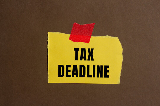 Tax deadline message written on ripped torn paper background. Conceptual Tax deadline symbol. Copy space.