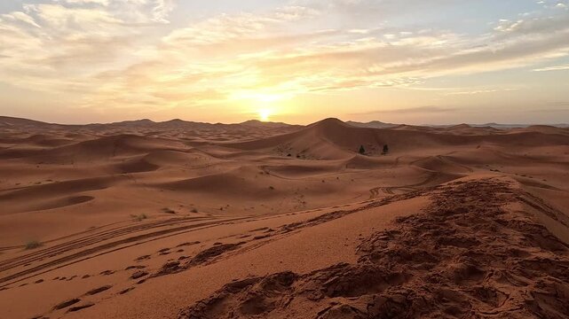 Sun setting over the rolling dunes of Erg Chebbi, Merzouga, Morocco, golden dusk light