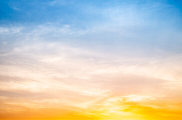 Fototapeta premium Sunset or sunrise sky with a vibrant gradient of orange, gold, and soft blue. Clear atmosphere with wispy clouds. Peaceful, natural light background. hope, freedom, new day and inspirational Concepts