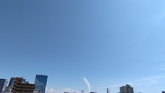 澄み渡る大空を描く飛行機雲とアクロバット飛行の航跡