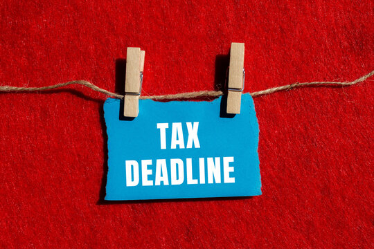 Tax deadline message written on ripped torn paper background. Conceptual Tax deadline symbol. Copy space.