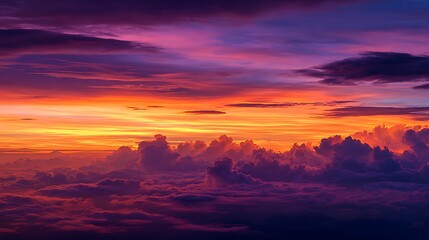 Obraz premium Vibrant sunset sky with dramatic clouds painted with fiery orange pink and purple hues creating a breathtaking natural backdrop for travel or atmospheric concepts