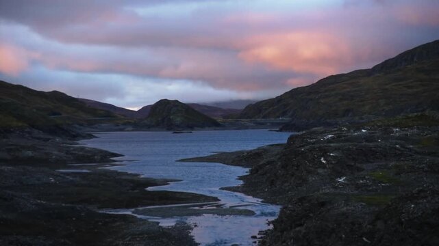 Pink afterglow over a rocky reservoir and inflow stream along the Sognefjellsvegen, Jotunheimen, Norway