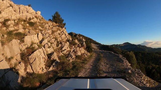 POV of an off-road vehicle driving on a gravel trail in the mountains of Montenegro