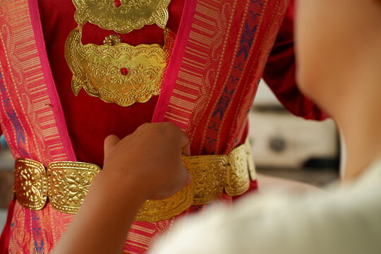 Close-up of bride wearing traditional Indonesian golden headpiece and jewelry