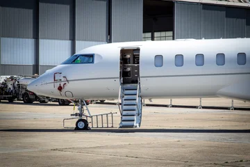 Private jet with open stair door on the tarmac of an airport. © VanderWolf Images