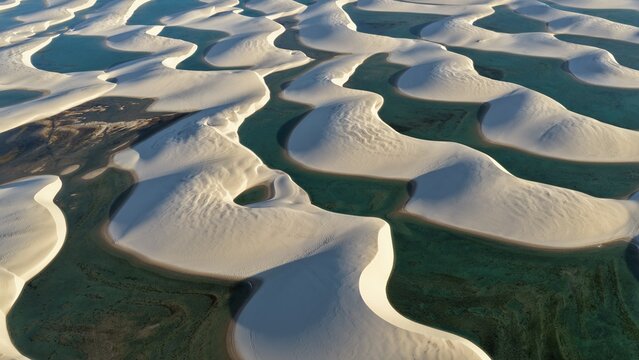 Aerial view of the white sand dunes and turquoise lagoons of Parque Nacional dos Lencois Maranhenses in Atins, Maranhao, Brazil.