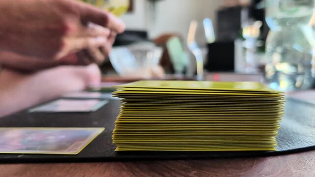 Close up video of hands arranging collectible trading cards on a tabletop, illustrating card collecting as a modern hobby, tabletop gaming culture and the careful organization of a collection