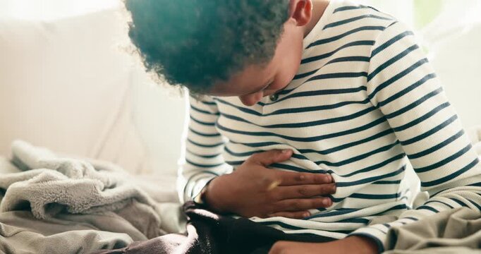 Hands, child and stomach ache in home, sick or uncomfortable with irritable bowel syndrome. Health risk, abdomen pain and boy with constipation, gas bloating or diarrhea problem with food poisoning