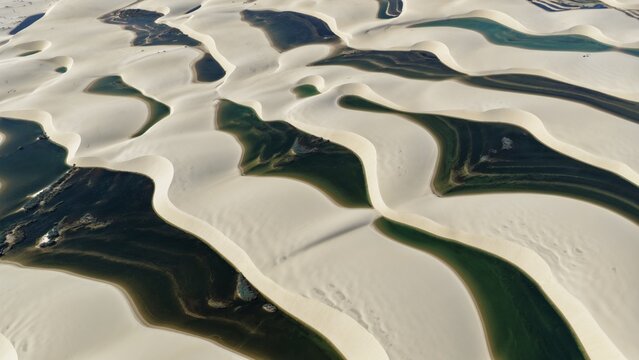 Aerial view of the white sand dunes and turquoise lagoons of Parque Nacional dos Lencois Maranhenses in Atins, Maranhao, Brazil.
