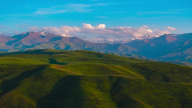 aerial drone hyperlapse above green foothills in Kyrgyzstan at summer evening