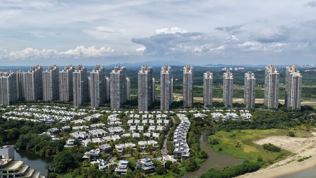 Aerial view of Forest City with modern high-rise residential towers and low-rise villas surrounded by lush greenery and coastal landscape in Gelang Patah, Johor Darul Ta'zim, Malaysia.