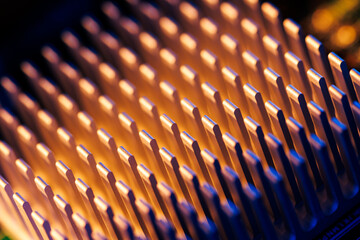 Obraz premium Closeup metallic heatsink fins macro background with blue and orange neon lighting for technology