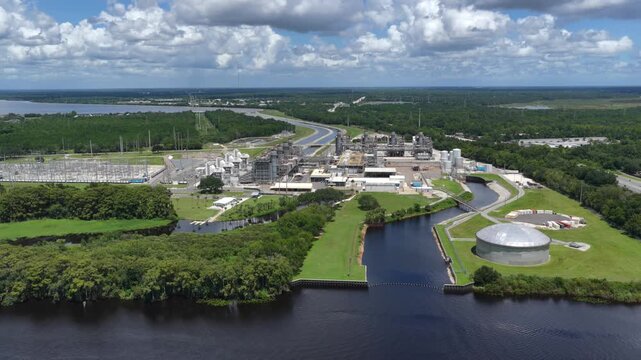 Aerial view of FPL Sanford Power Plant featuring industrial infrastructure, storage tanks, and power lines along the St. Johns River in DeBary, Florida, United States.