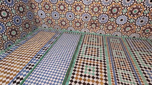 Rosette walls fanning into banded floor tiles, Saadian Tombs, Marrakech, Morocco, converging zellij geometry in soft light