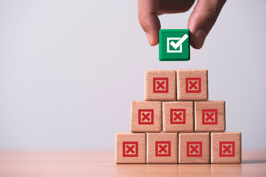 Failure and success concept showing a hand choosing the correct option among failed choices to represent smart decision making, problem solving, improvement and achieving successful business results.