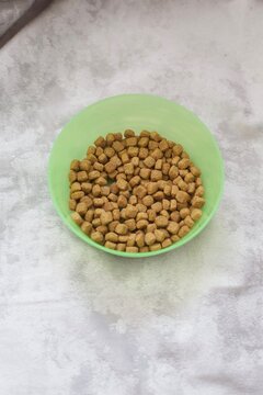Dry cat food in green bowl