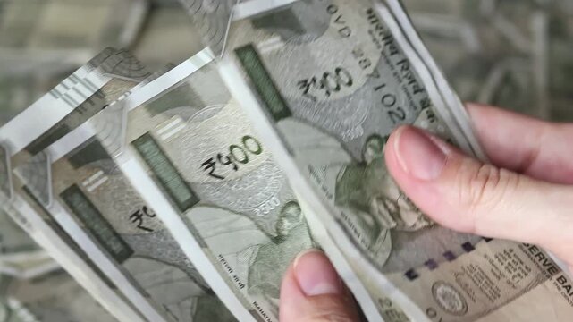 Woman's hands counting Indian 500 rupee banknotes (INR). Close-up view of Indian cash money. Real time motion video.