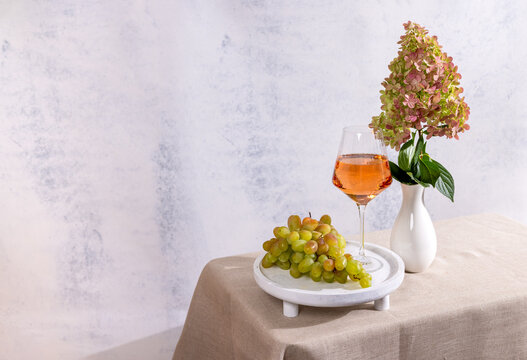 Rose wine glass with grapes and hydrangea flowers