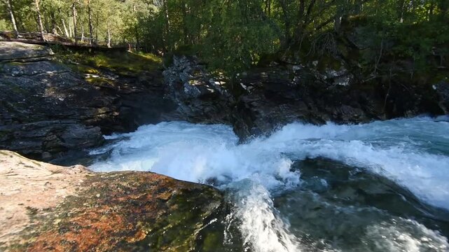 Sunlit birch and rock gorge with fast meltwater, Gudbrandsjuvet, Valldal, More og Romsdal, Norway