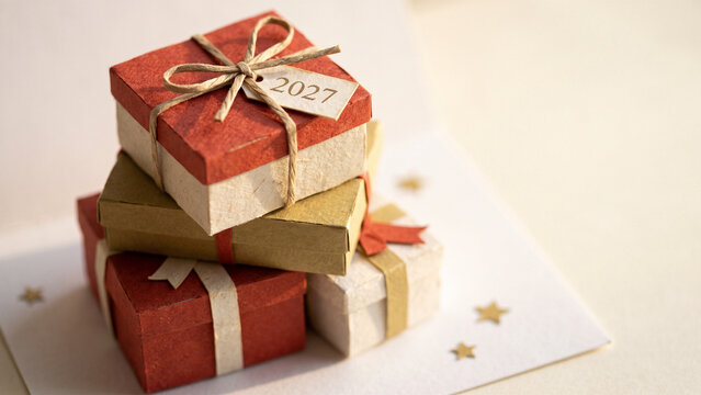 Celebrate the 2027 new year with a stack of rustic gift boxes and festive holiday decorations for a joyful surprise.