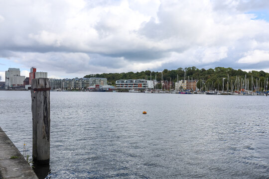 Flensburg, Germany - 17. August 2026: Waterfront view showing marina, city buildings, and industrial port